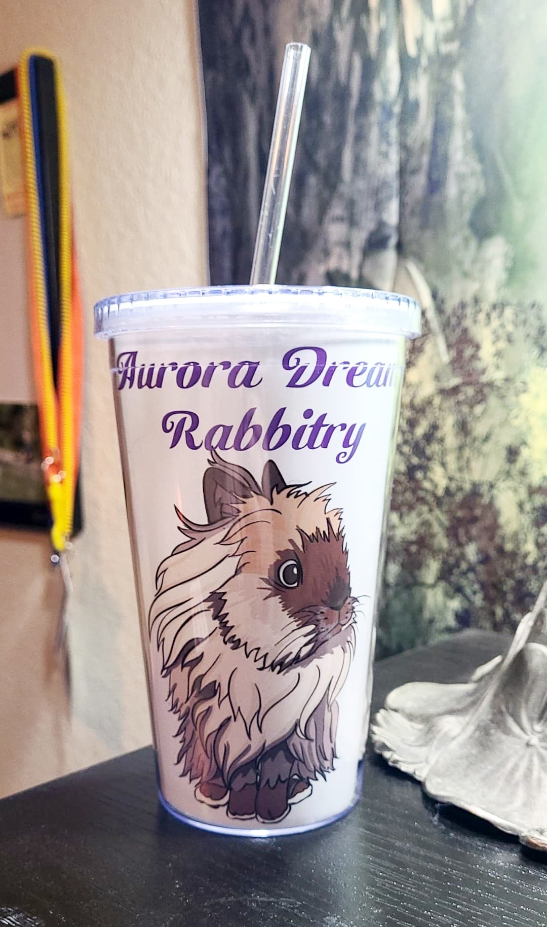 A photograph of a bottle with an illustration of a fluffy rabbit and the words "Aurora Dream Rabbitry" on the side.