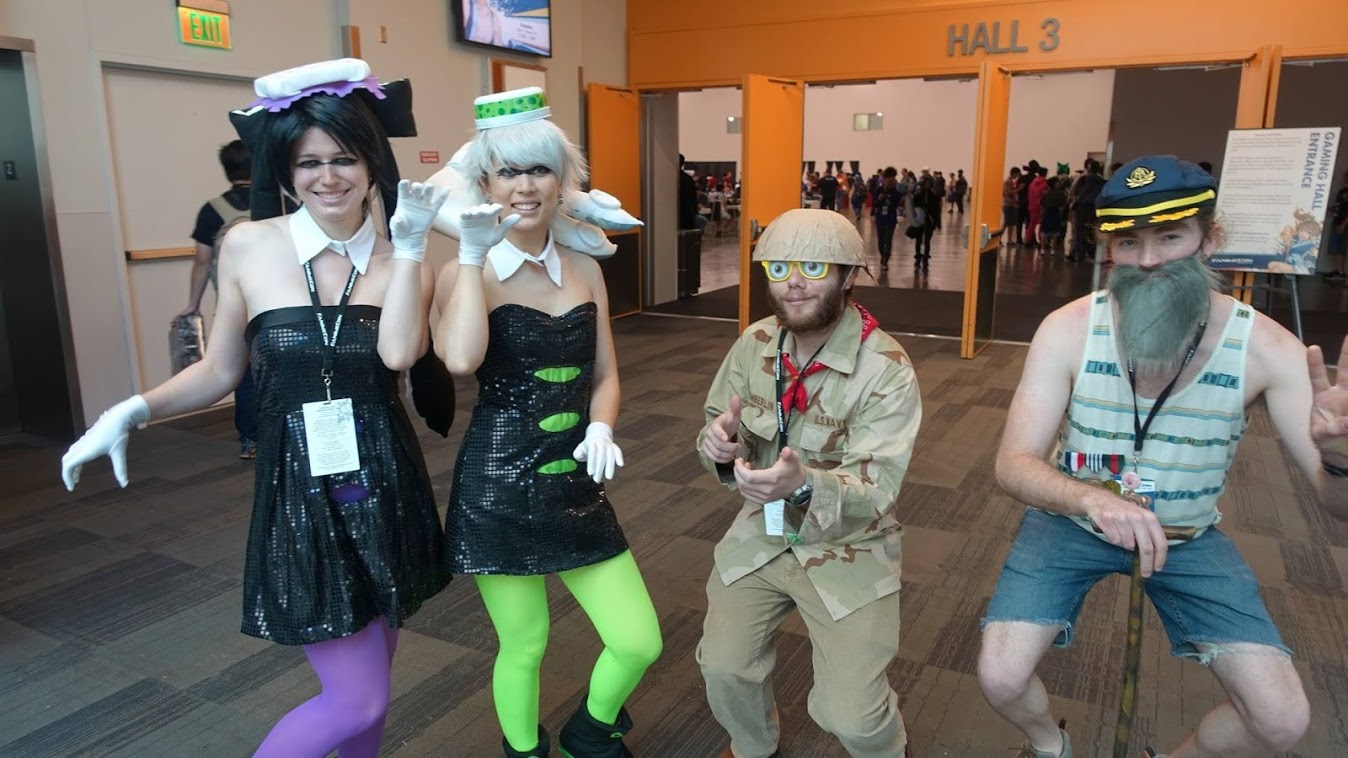 A photograph of 4 young adults posing for the camera in colorful costumes