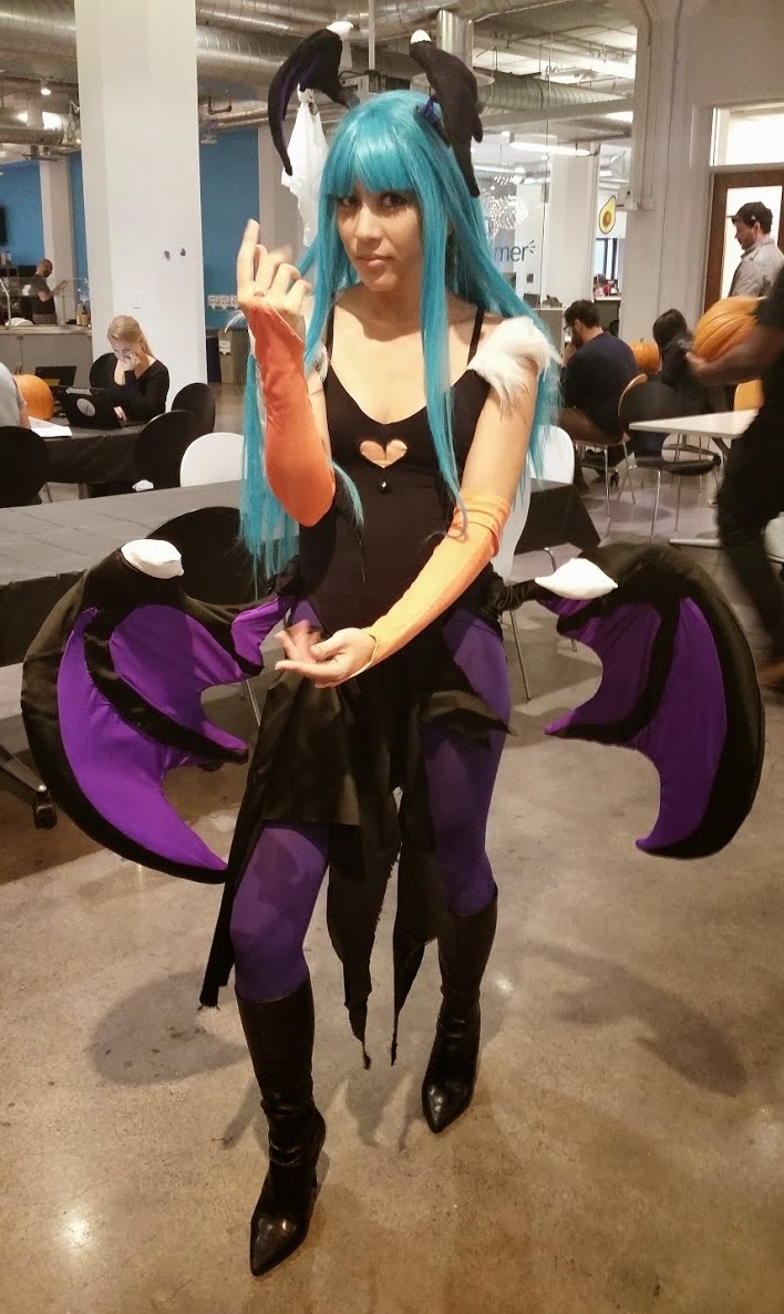 Photograph of a girl wearing a teal wig and a giant set of wings around her waist