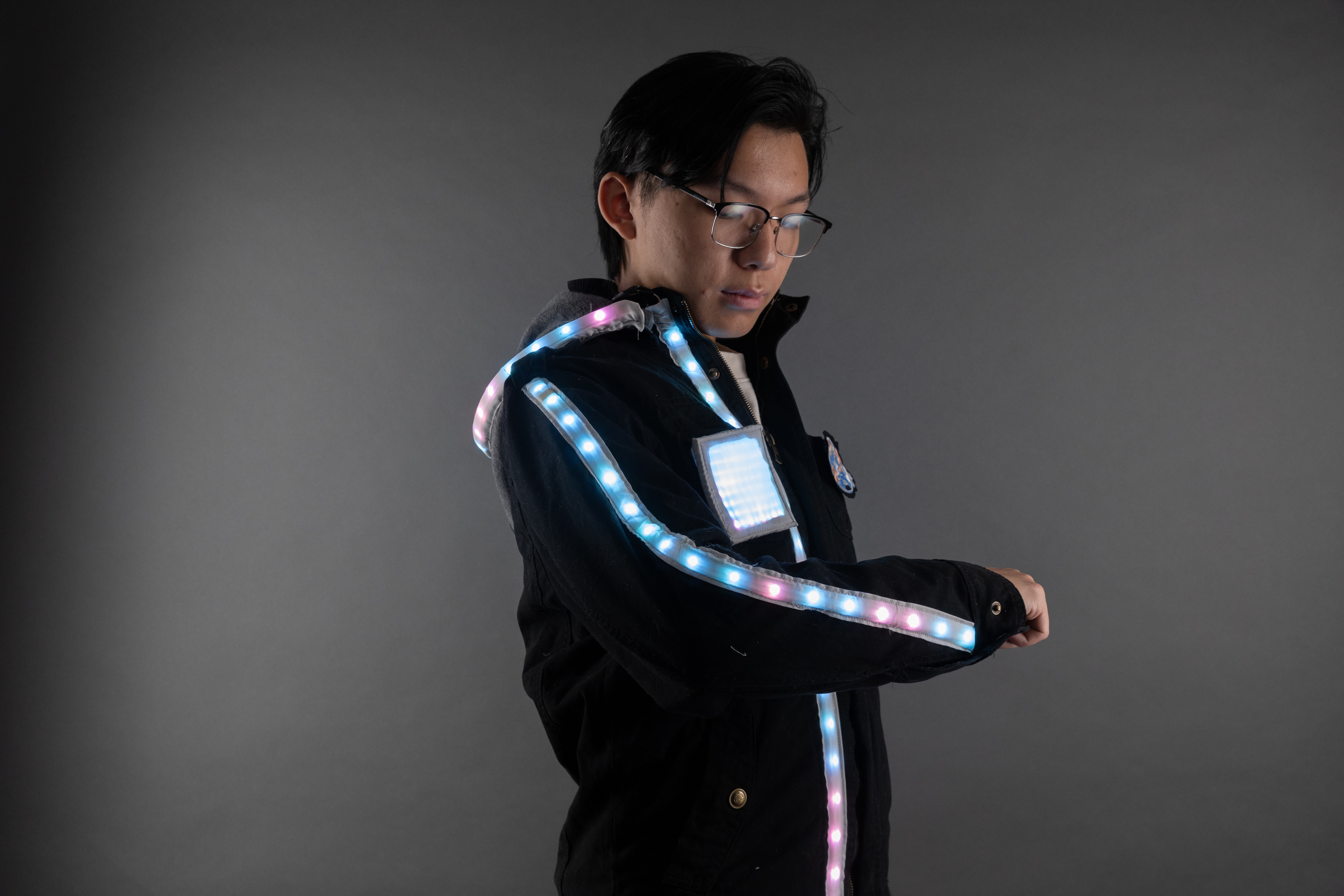 Photograph of a man looking at the LED strip along his jacket arm