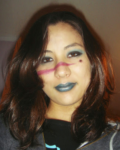 Photograph of a girl with brown hair with elaborate magenta and green makeup on