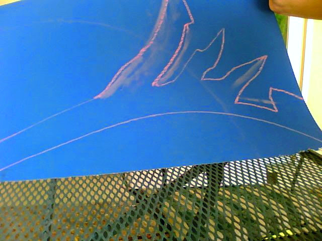 Photograph of a drawing of a blade on a black posterboard