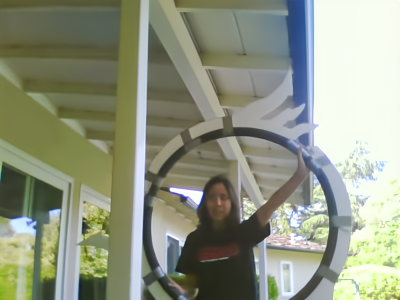 Photograph of a girl holding up a hula hoop with cut out blades duct taped on