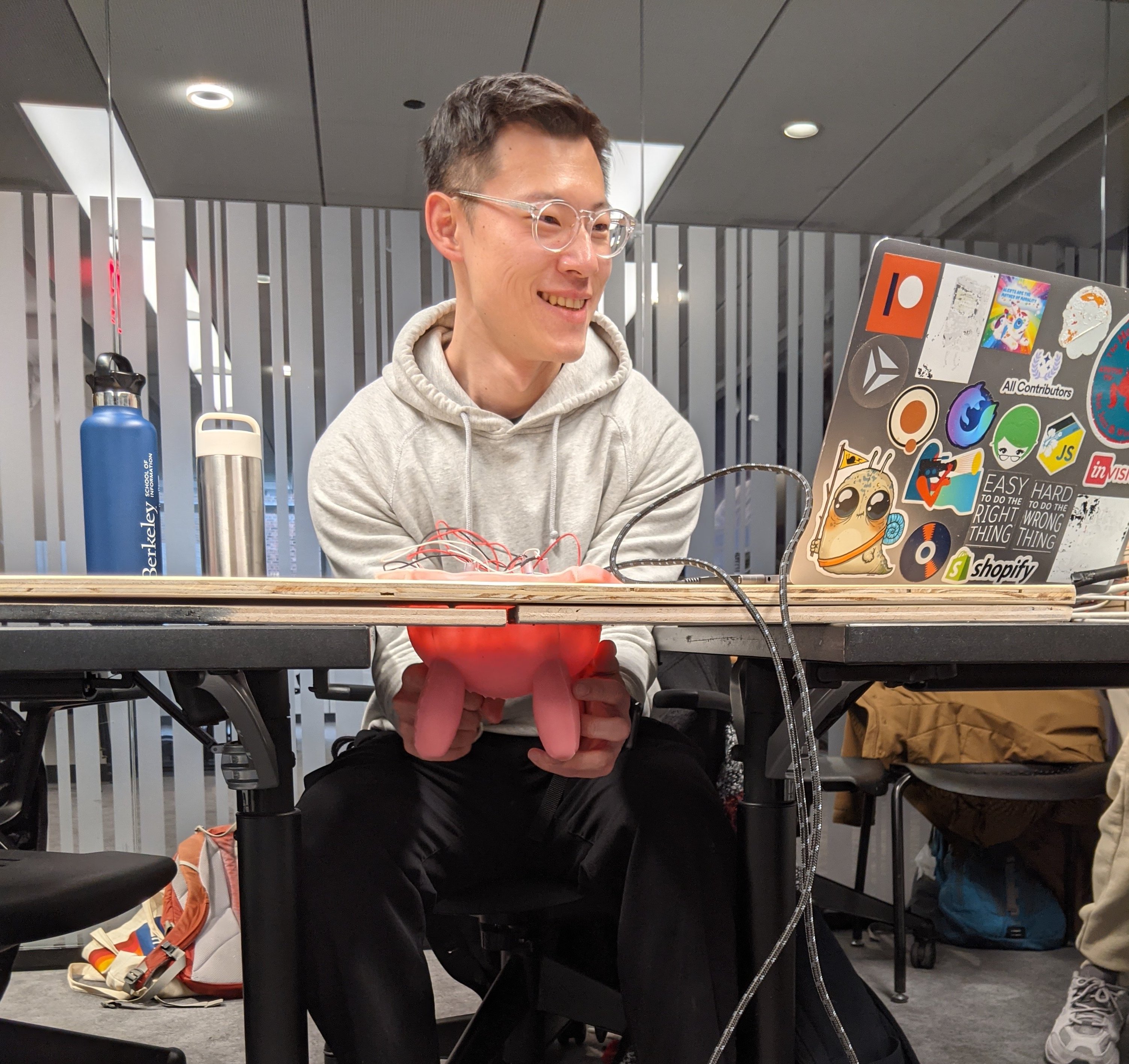 Photo of a man smiling while squeezing an udder hanging from a table